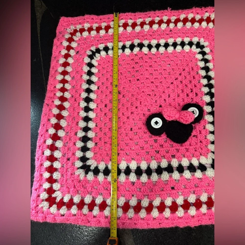This is a handmade crocheted Minnie Mouse granny square blanket.